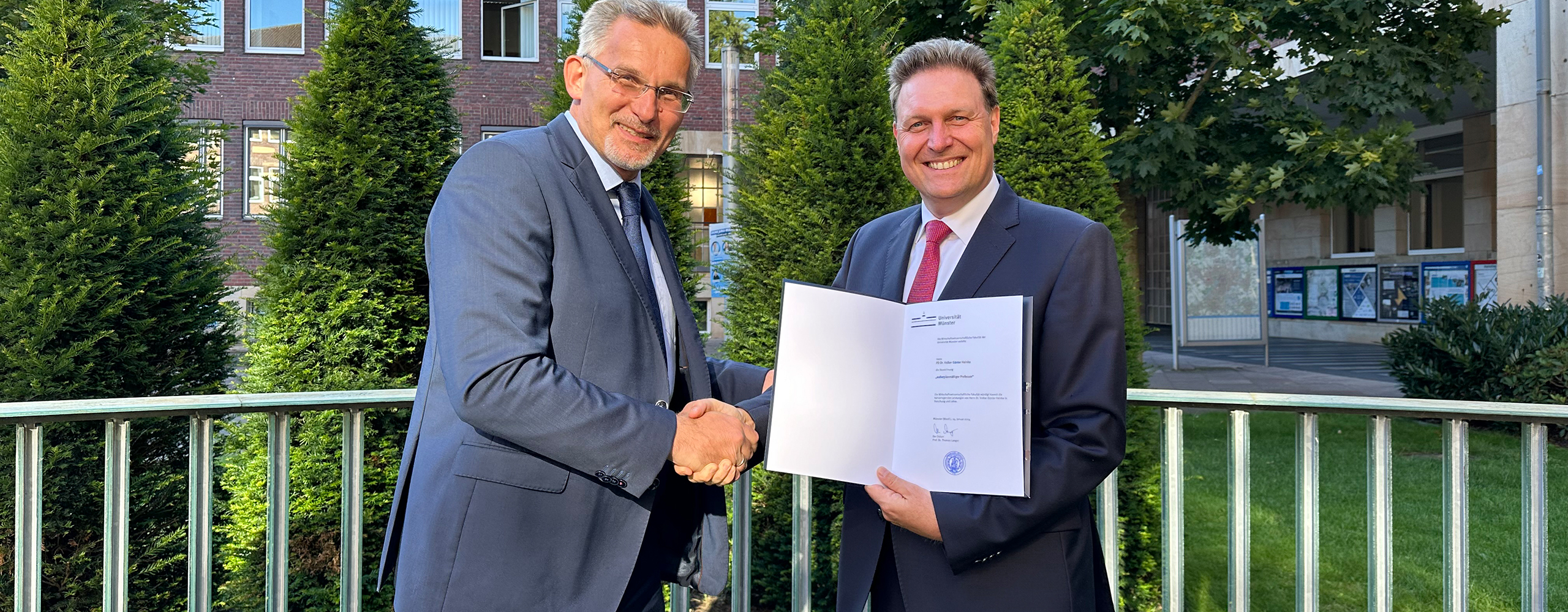 Der Dekan der Wirtschaftswissenschaftlichen Fakult&auml;t der Universit&auml;t M&uuml;nster, Prof. Dr. Thomas Langer, &uuml;berreicht Dr. Volker Heinke die Ernennungsurkunde.
