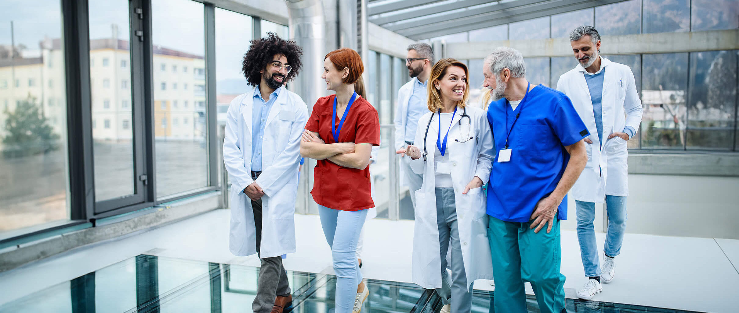 Eine Gruppe von Besch&auml;ftigten eines Krankenhauses laufen in einem Flur