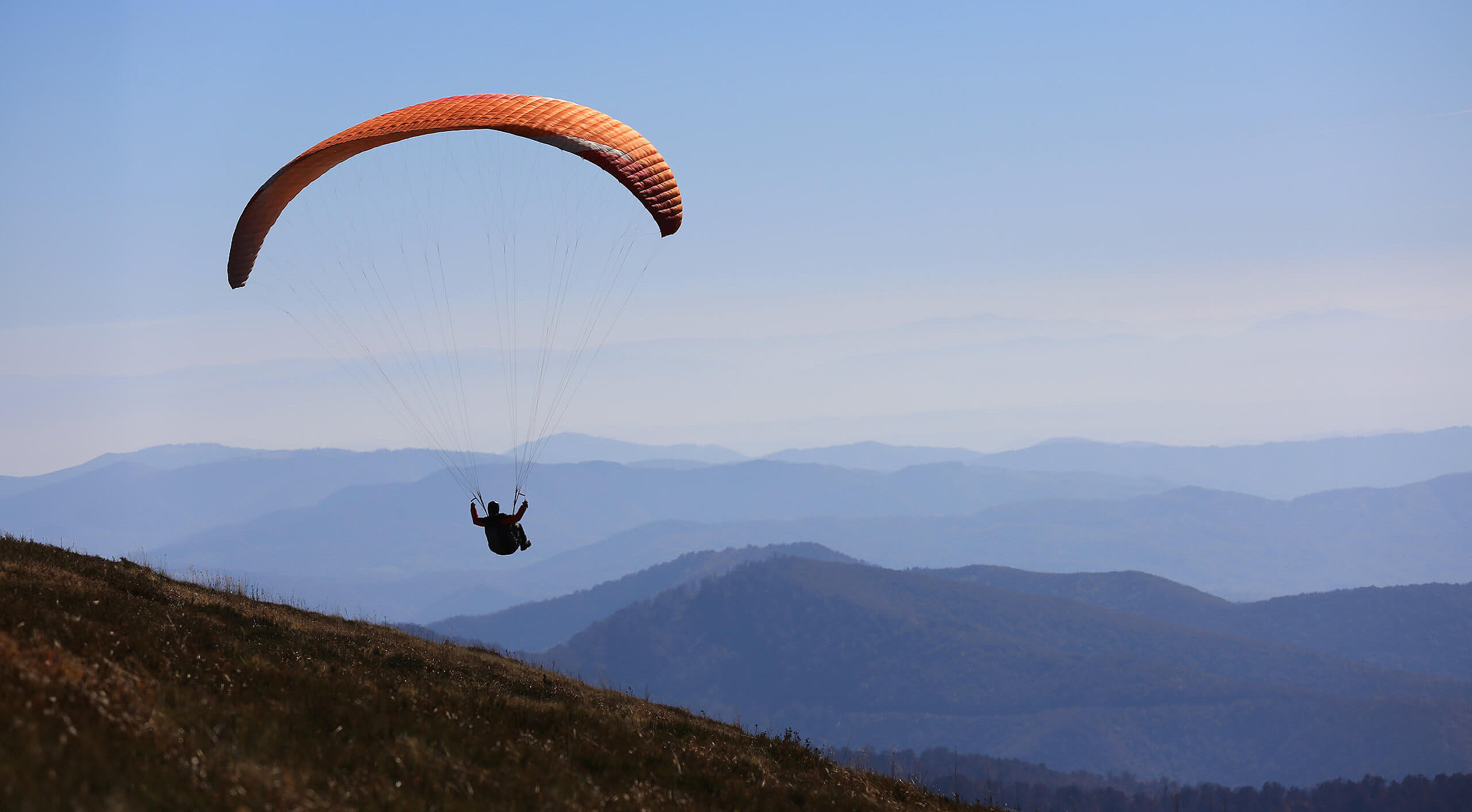 Fliegender Gleitschirm in den Bergen